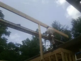 Carpenter setting a ridge beam over a new addition frame — Ice Dam Removal by Roofing Brothers in Pawling