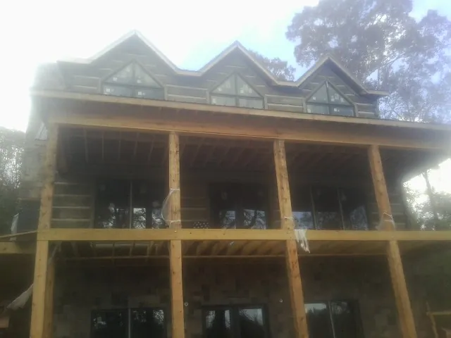 Dormers and porch framing on a large log home under construction — Roof Coating work by our crew in Pawling