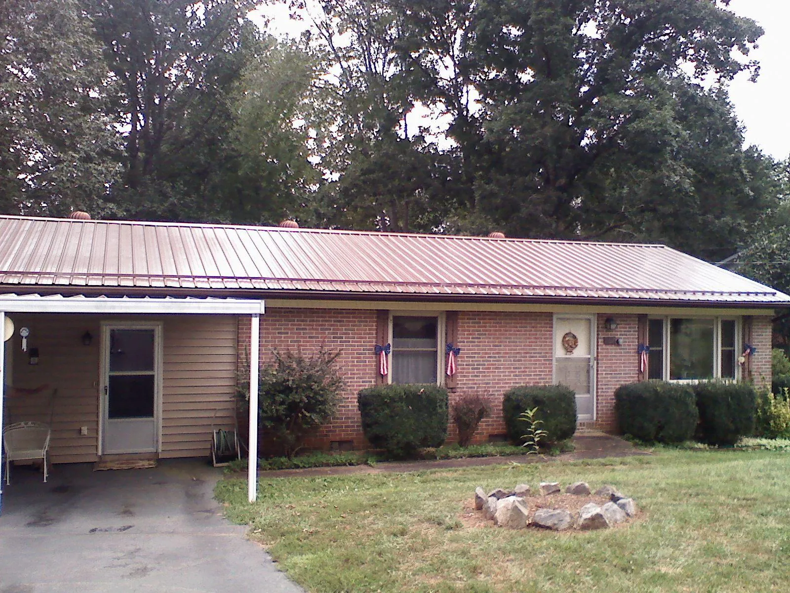 Bronze metal roof and carport on a brick ranch home — Roof Repair work by our crew in Pawling